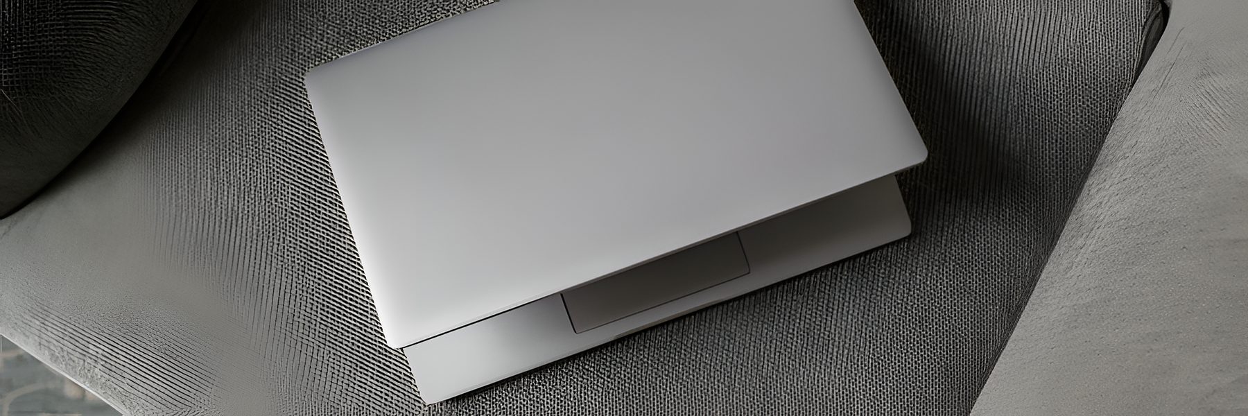 Closed laptop resting on a sofa